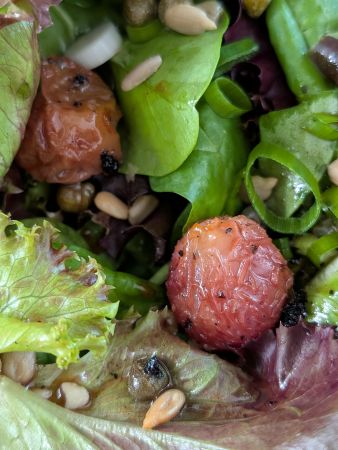 close-up of charred grape on a bed of lettuce