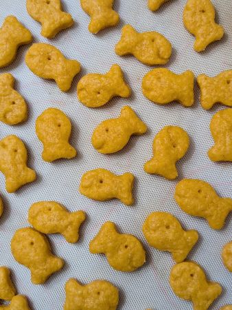 silicone-lined baking tray with a single layer of homemade vegan Goldfish crackers