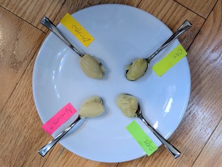tasting spoons filled with 4 different crèmes anglaises: soy, oat, cashew, and almond milks